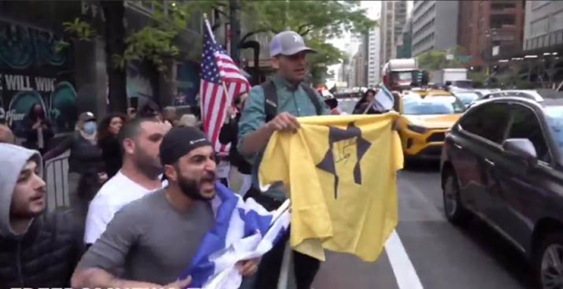 Protestor waving a Kach t-shirt